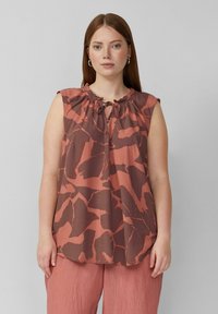 T-shirt sans manches en rouille et marron avec un motif floral, encolure froncée et liens à l'avant. Tissu léger, coupe décontractée.