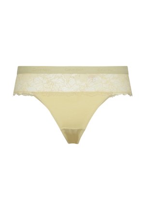Gele katoenen string in een katoenmix met een bloemenkant tailleband. De tailleband heeft een gegolfde rand en is gedrukt met "Calvin Klein."
