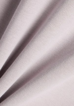Tissu rose pâle doux avec une texture fine en tricot et des plis légers créant des lignes diagonales ombrées sur la surface.