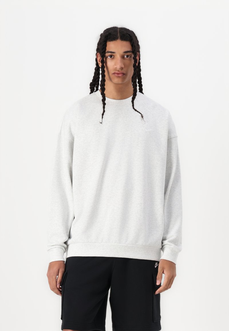 Lys grå sweatshirt med en afslappet pasform, rund halsudskæring og ribbede manchetter. Har et lille logo på venstre bryst og en tekstureret stof.