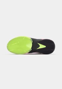 Suola di scarpa con una superficie in gomma verde neon prominente, caratterizzata da motivi circolari testurizzati, in contrasto con una sezione nera e accenti rosa.