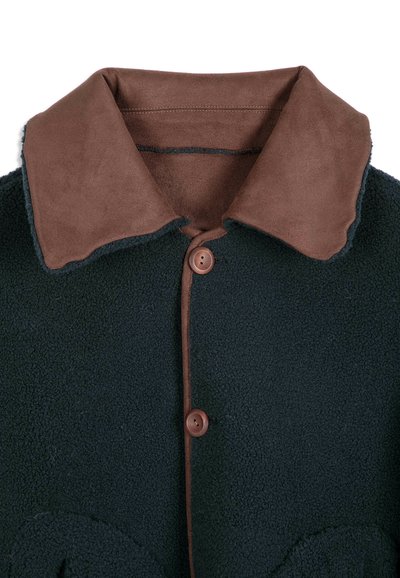 Veste en polaire vert foncé avec grand col en daim marron et deux boutons marron sur le devant.