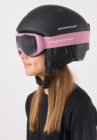 Zwarte skihelm met een verstelbare roze band met het "SWEDEMOUNT" logo. Donkere skibril met een roze montuur. Gestructureerde zijpanelen.