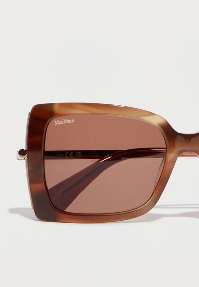 Καφέ υπερμεγέθη τετράγωνα γυαλιά ηλίου MaxMara με διαφανή πλαίσια και σκουρόχρωμους φακούς σε λευκό φόντο.