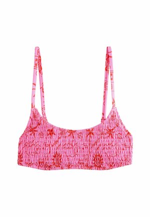 Pink smocked crop top with thin straps, featuring a textured fabric and a subtle floral pattern in red. Elasticated for a fitted look.