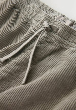 Hellgraue, gerippte Loungehosen mit einem elastischen Bund und verstellbarem Kordelzug. Das Etikett zeigt den Markennamen "NEXT." Weicher Stoff.