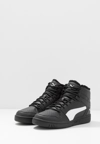 Black high-top Puma sneakers with white side stripe, laces, and plush inner lining, shown on a white surface with a plain background.