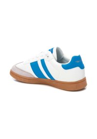 Sneaker bianca con accenti blu e tre strisce blu, dotata di suola in gomma e punta in suede. Parte superiore in pelle testurizzata.