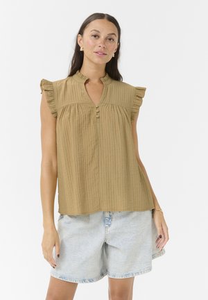 Haut marron texturé avec des manches en capes froncées, détails de boutons et coupe décontractée, associé à un short en denim bleu clair.