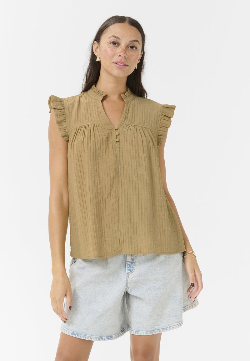 Top marrón texturizado con mangas cortas rizadas, detalles de botones y un corte relajado, combinado con shorts de mezclilla azul claro.
