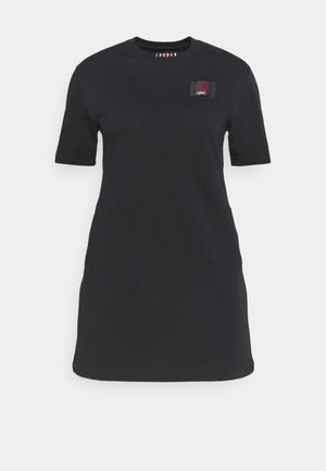 Musta puuvillainen T-paita mekko lyhyillä hihoilla, pyöreä kaula-aukko ja pieni kudottu logopatchi vasemmalla rinnalla. Sujuva pinta, rento istuvuus.