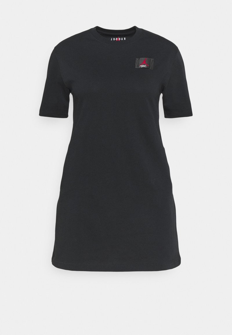 Czarna bawełniana sukienka T-shirt z krótkim rękawem, okrągłym dekoltem i małą tkana łatą logo po lewej stronie klatki piersiowej. Gładka tekstura, luźny krój.