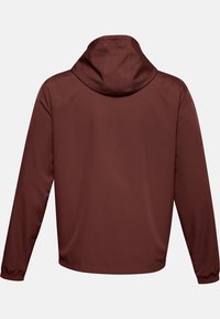 Chaqueta con capucha en marrón oscuro, fabricada en un tejido suave. Presenta mangas largas con puños elásticos y un diseño sin costuras sin cierres visibles.