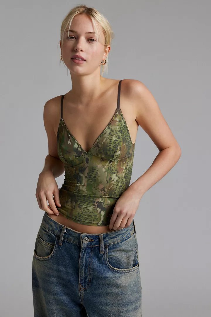 Top in camuffo trasparente verde e marrone, con spalline sottili e scollatura a V. Abbinato a jeans in denim a vita alta.