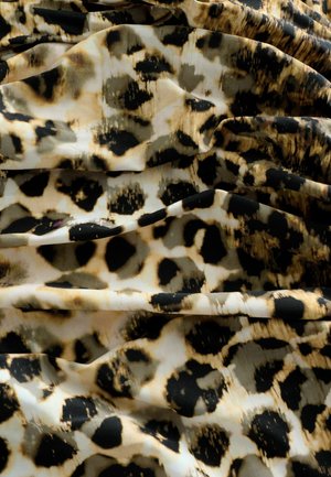 Țesătură cu imprimeu de leopard, având pete negre și maronii pe un fundal crem, cu o textură fină și un luciu subtil. Draperie șifonată.