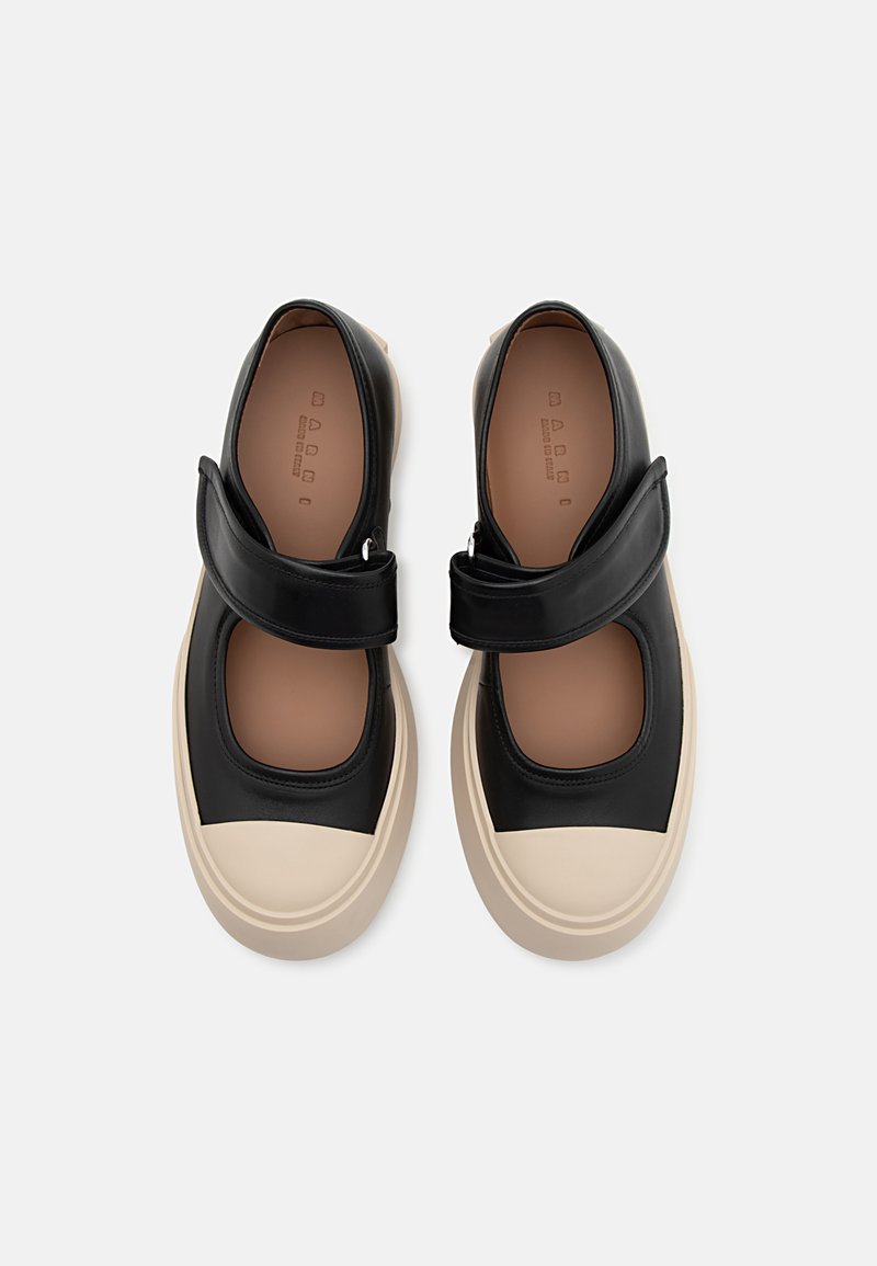 Schwarze Leder-Mary-Jane-Schuhe mit breitem Riemen, cremefarbener Gummisohle und runder Zehenform. Texturiertes Obermaterial mit Ausschnittdesign.