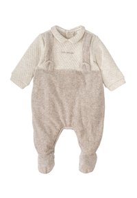 Mono de bebé de algodón beige con parte superior acolchada, textura suave, tirantes ajustables y diseño con pies. Presenta un collar redondo y detalles bordados.
