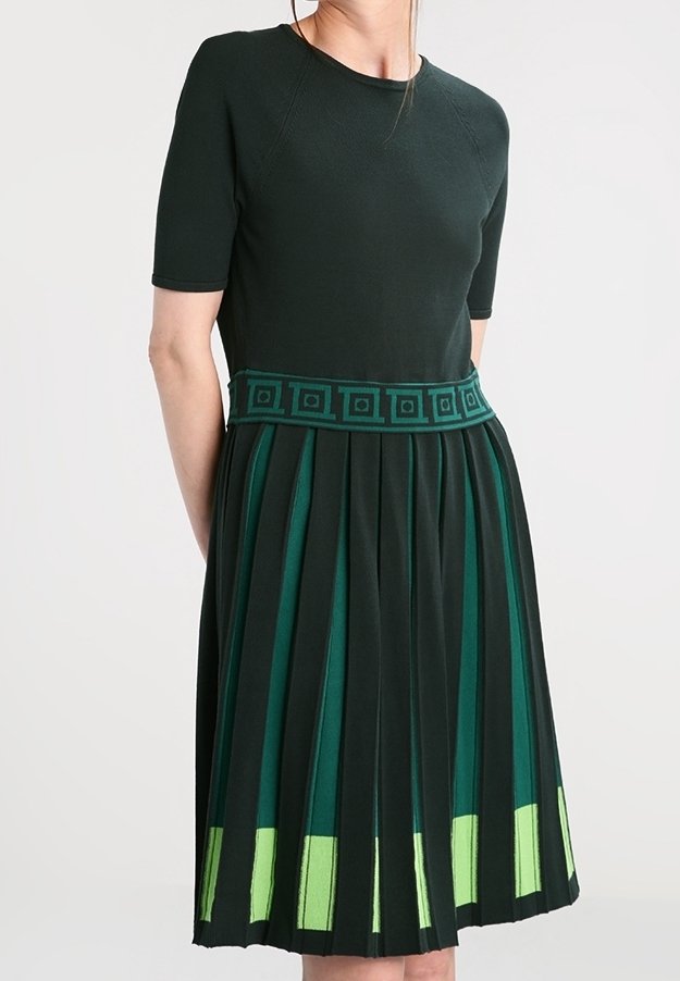 Robe vert foncé à manches courtes, avec une jupe plissée et une ceinture verte à motif. Détails d'ourlet en vert clair en accent.