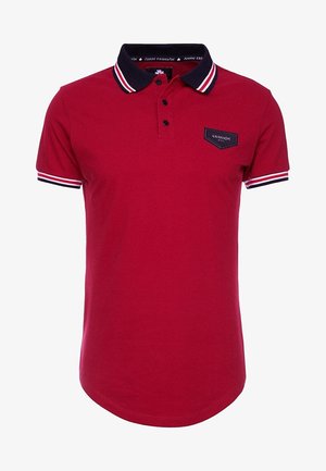 Polo rouge à manches courtes avec col noir et finitions des manches ornées de rayures blanches et rouges, trois boutons noirs et un petit patch logo noir sur la poitrine.