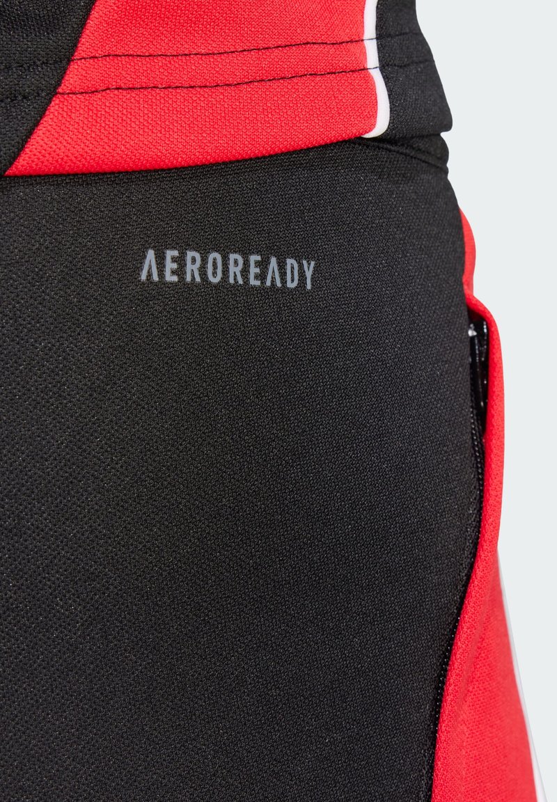 Tissu de sport noir avec des accents rouges, comportant une poche zippée et un logo "AEROREADY". La texture est lisse avec un design anti-humidité.