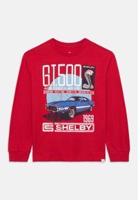 Κόκκινο μακρυμάνικο πουκάμισο με σχέδιο ένα μπλε Shelby GT500 του 1969, με λευκή γραμματοσειρά και λεπτομέρειες, κατασκευασμένο από υφασμένο βαμβακερό υλικό.