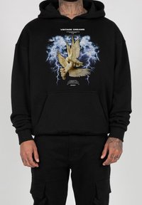 Black hoodie featuring a printed graphic of two doves surrounded by lightning, with “Vintage Dreams” text above and “Seasonz 2023” below.