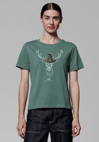 Grünes Kurzarm-T-Shirt aus Baumwolle mit Rundhalsausschnitt. Mit einem Aufdruck eines Rehs, das einen Hut trägt, in Weiß und Schwarz.