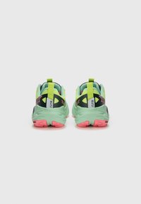 Green sneakers with black accents, pink outsole, textured surface, and high-visibility design. Features rear pull tab and ventilation cutouts.