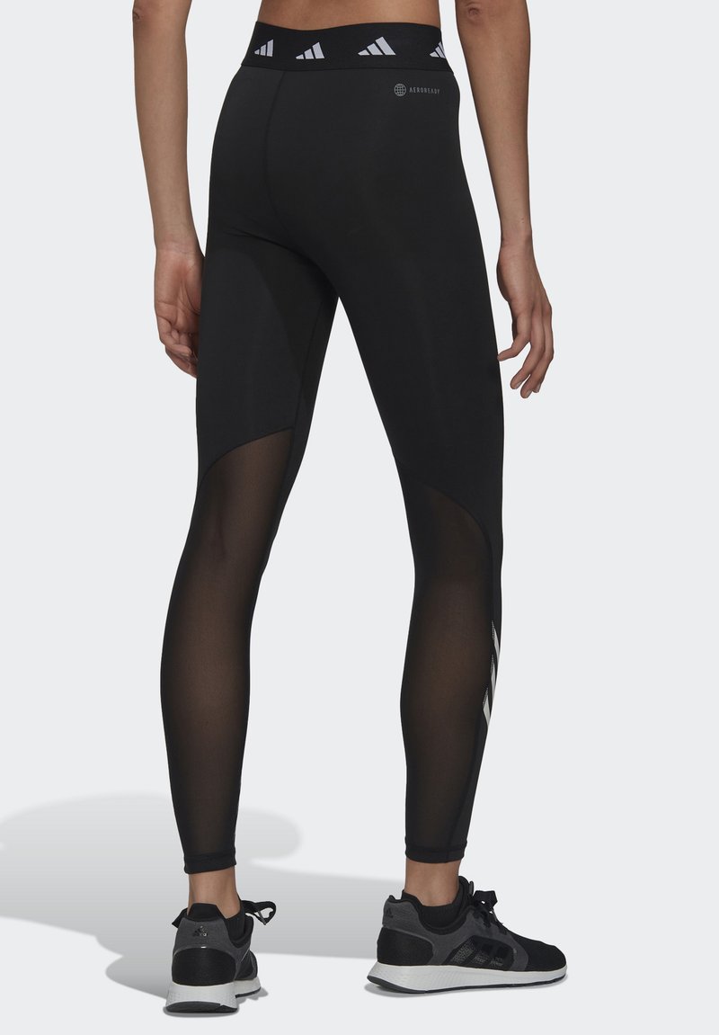 Leggings deportivos negros con un ajuste tapered, que cuentan con paneles de malla y una cinturilla con marca. Tejido texturizado con un acabado suave.