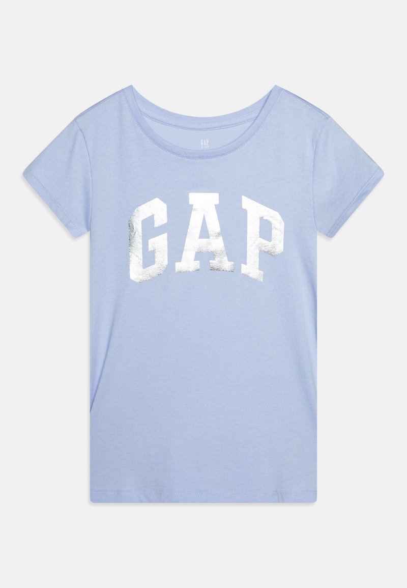 Šviesiai mėlyna trumpomis rankovėmis marškinėliai su apvaliu kaklu, ant kurių priekyje išdidžiai pavaizduotas didelis sidabrinis metalinis "GAP" logotipas.