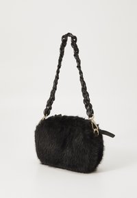 Sac à main en fausse fourrure noire de forme arrondie, doté d'une bandoulière en cuir tressé et d'accents en métal doré. Sa texture douce renforce son attrait visuel.