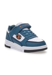 Zapatillas en color azul verdoso y blanco con una parte superior de piel suave, puntera perforada, cordones azules y una correa de Velcro. Presenta el logotipo de Champion en color naranja.