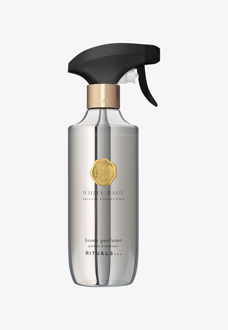 Flacon spray transparent étiqueté parfum d’intérieur Rituals White Basil avec sceau doré et pulvérisateur noir à gâchette.