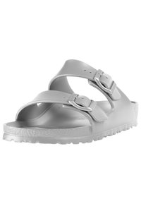 Sandali in plastica grigia con due cinturini regolabili dotati di fibbie metalliche, suola testurizzata e design aperto sulla punta. Leggeri e flessibili.