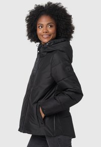Black insulated jacket with a hood, zippered front, side pockets, and logo detail on the sleeve. Smooth, matte texture throughout.