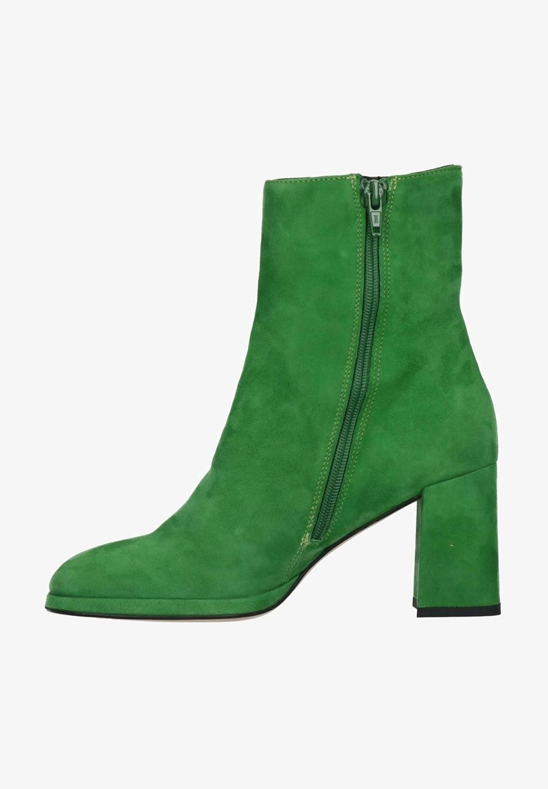 Bottine en daim vert à talon carré avec fermeture éclair latérale, présentée de profil sur un fond blanc.