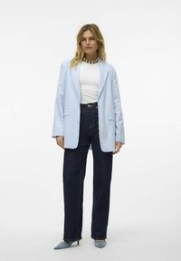 Blazer bleu clair avec un col cranté, assorti à une chemise blanche et un pantalon large en denim foncé. Fini avec des escarpins pointus bleu clair.