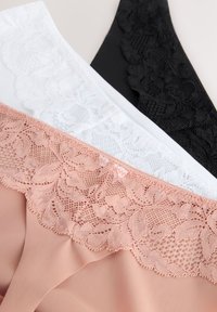 Lenjerie cu dantelă în negru, alb și roz pal, cu diferite modele de dantelă și texturi fine de stofă. Trei piese așezate plat.