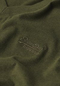 T-shirt in cotone verde oliva con una texture morbida e logo ricamato "SuperDry" in una tonalità abbinata sul petto.