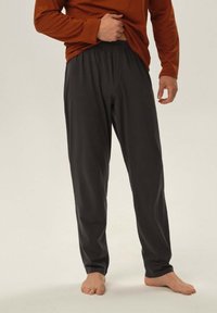 Ciemnoszare, lekkie spodnie z elastycznym pasem i luźnym krojem, połączone z rdzawą bluzką z długim rękawem.