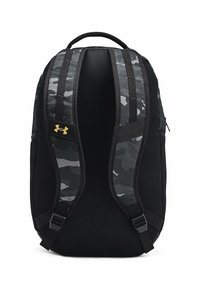 Sac à dos camouflage noir et gris avec tissu en maille au dos et sur les bretelles, doté de boucles latérales réglables et d'un accent logo doré.