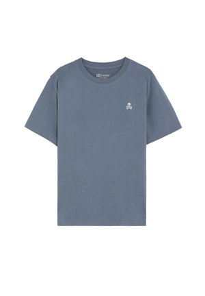 Camiseta lisa azul de manga corta con cuello redondo y un pequeño logo blanco de calavera y tibias cruzadas en el pecho izquierdo.