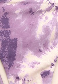 Fialová látka s tie-dye vzorem a krémovými akcenty, s hladkou texturou a kombinací jemných, tlumených barev.