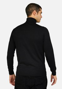 Maglione nero a maniche lunghe con collo alto e orlo a coste. Realizzato in un materiale intrecciato liscio, aderente in vita.