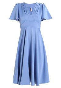 Blauwe jurk van zachte stof, met korte mouwen, een V-hals, een geplooide boezem en een uitlopende rok die onder de knie valt.