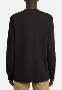 Schwarzes Langarmshirt mit rundem Ausschnitt, das eine glatte Textur und eine lockere Passform aufweist, von hinten betrachtet.