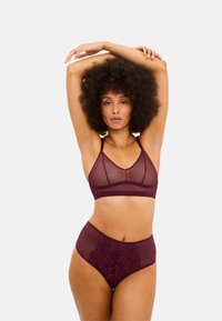 Burgundy nät-bra med geometriska utskärningar och justerbara band, i kombination med högmidjade trosor med spetsdetaljer i matchande färg.