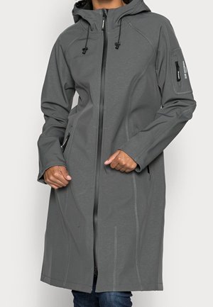 Persona que lleva una chaqueta gris larga con capucha, cremallera frontal y bolsillos con cremallera, uno en la manga y dos a los lados.