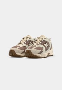 Brown and beige running shoes with mesh and suede materials, lace-up design, padded collar, and textured rubber soles.