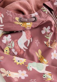 Tessuto rosa con motivi fantasiosi di animali, tra cui un unicorno, un coniglio, un cervo e un sole, con una morbida fodera in pile visibile.